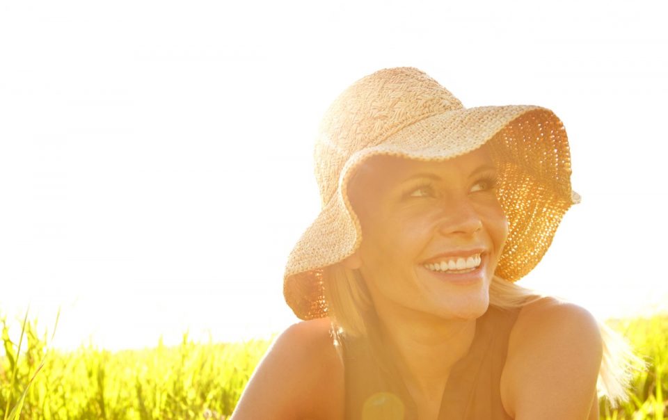 A beautiful young blonde woman sitting in a field